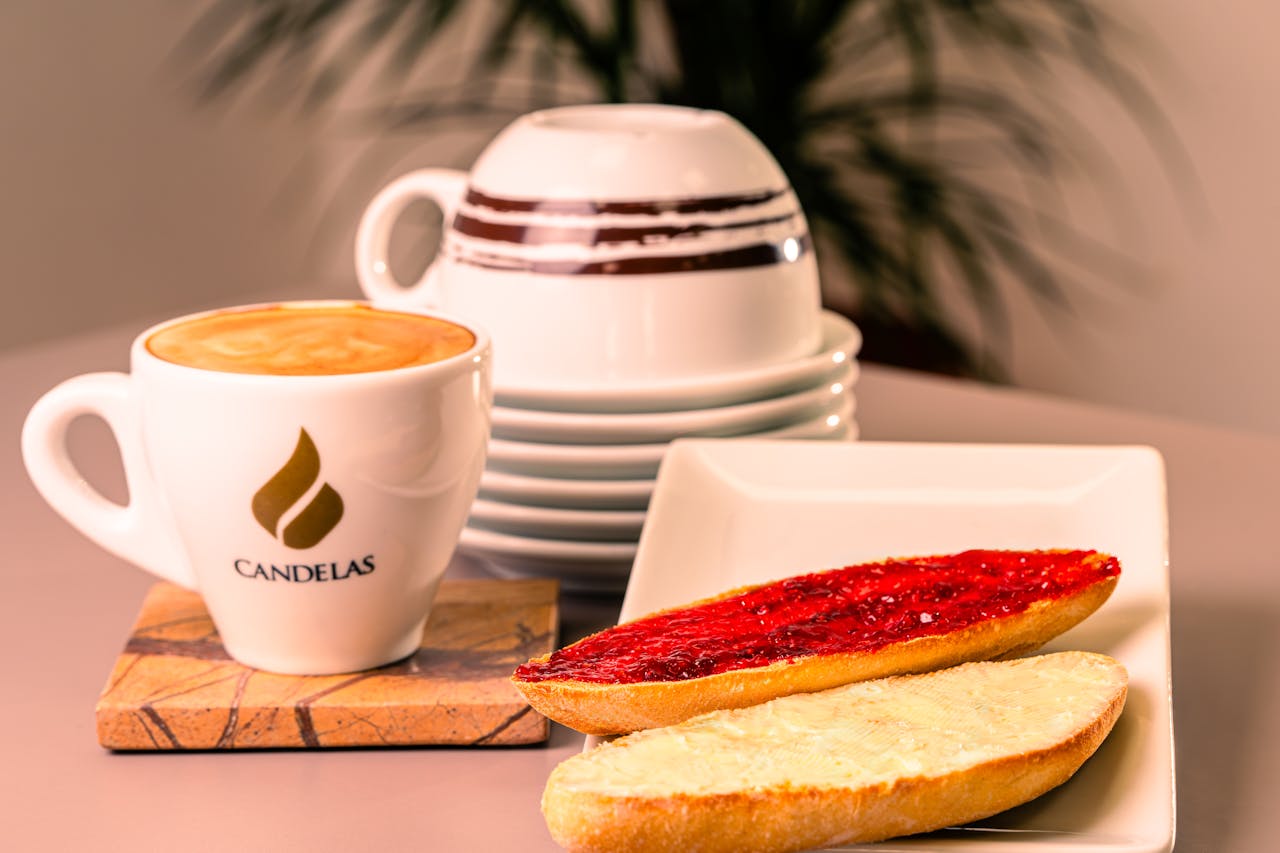 Warm morning breakfast with coffee, toast, and jam in a cozy setting.